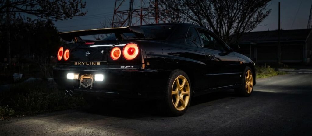 Black Nissan Skyline parked at night, a popular Nissan performance car imported from Japan.