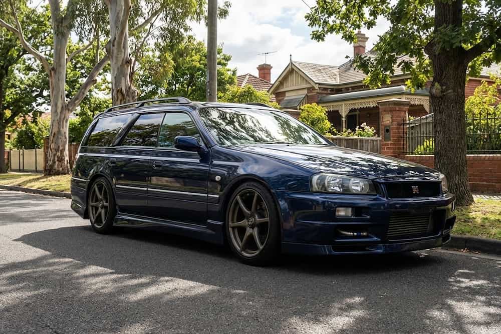 Dark blue Nissan Stagea performance wagon parked on a suburban street, a popular Japanese import car.